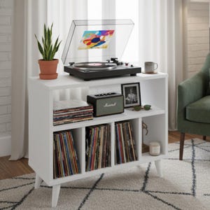 Può includere: Un mobile bianco per giradischi con giradischi nero, dischi in vinile e altoparlante Marshall. Una pianta in vaso e una foto incorniciata sono anche sul mobile. Design moderno della metà del secolo.