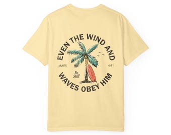 Camiseta con tabla de surf y palmera / Diseño con la cita bíblica "Hasta el viento y las olas le obedecen"