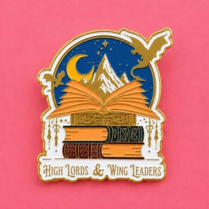 May include: Enamel pin depicting a stack of books with an open book on top. The design includes a mountain range, crescent moon, stars, and dragons, set against a blue backdrop. The text "High Lords & Wing Leaders" is at the bottom.