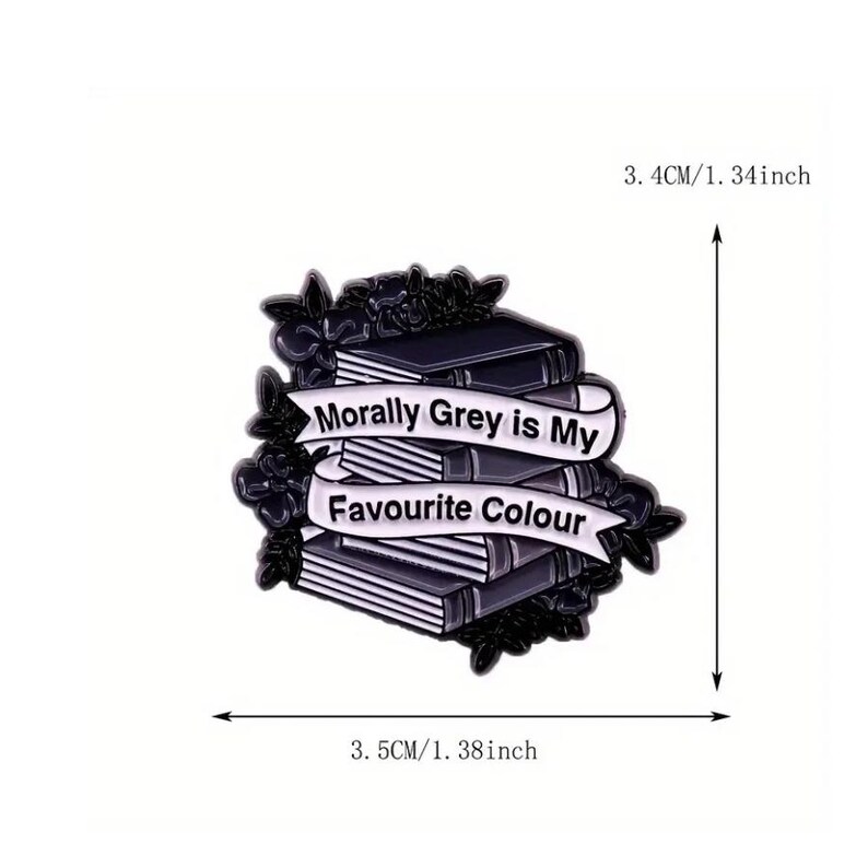 May include: A black and white enamel pin featuring a stack of books surrounded by floral details. A white banner across the books reads "Morally Grey is My Favourite Colour". The pin measures 3.4 inches by 3.5 inches as indicated by the arrows.