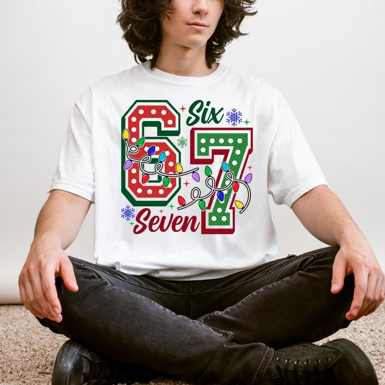 A person wearing a white t-shirt with a graphic design featuring the number "67" and the text "Six Seven" printed on it.