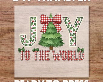 May include: A DTF transfer with the words "JOY TO THE WORLD" in a festive design. The letters are decorated with holly and plaid patterns, with a Christmas tree and bow in the center. The words "READY TO PRESS" are at the bottom.