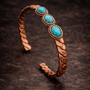 Puede incluir: Brazalete de puño en tono cobre con un diseño trenzado. El brazalete presenta tres piedras turquesas ovaladas engastadas en un marco con cuentas. El diseño de puño abierto permite un uso fácil. Una joya elegante.