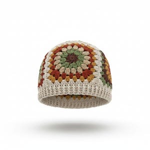 May include: A crochet beanie featuring a multi-colored granny square pattern in shades of cream, rust orange, mustard yellow, olive green, and dark brown. The hat has a ribbed cream-colored brim and a rounded crown constructed from yarn.