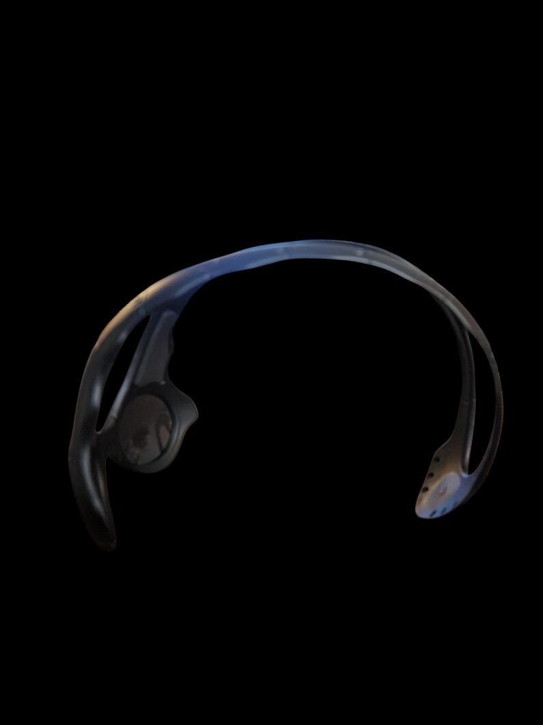 May include: Black and blue sports headphones with a curved design. The headphones have a sleek, modern aesthetic, with a focus on ergonomic design for comfort during workouts or other activities. The ear pieces are visible.
