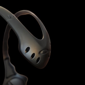 May include: A dark gray kitchen ladle with a curved handle and a rounded head featuring three oval holes. The ladle is made of a smooth, possibly metallic material, and is set against a black background.