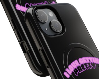 May include: A black smartphone case featuring a circular magnetic charging ring design and the text I LOVE GETTING PRETTY in a bright pink, bubble-style font. The case has a glossy finish and cutouts for the camera lenses and side buttons.