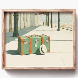 May include: A framed print of a vintage travel scene. A green trunk with orange trim and a white hat sit on a train platform. In the background, a couple walks away, and a clock hangs above. The scene is painted in soft, muted colors.