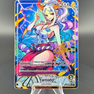 May include: A white ceramic mug with a black handle and the text "But First, Coffee" in a bold, black font. The mug is set against a blurred background, suggesting a cozy setting.