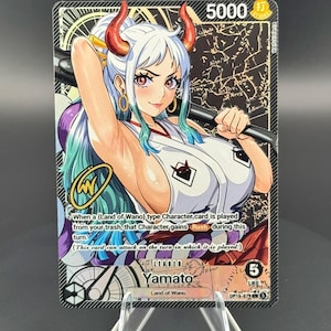 May include: A One Piece trading card featuring the character Yamato with white and teal hair, red horns, and a white sleeveless top. The card displays the text 'Leader', 'Yamato', 'Land of Wano', and game mechanics, with a gold signature graphic on the left side.