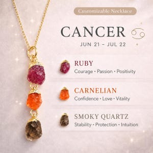 May include: A gold-colored necklace featuring three gemstone pendants: ruby, carnelian, and smoky quartz. The necklace is designed for the Cancer zodiac sign, with the text "CANCER" and dates "JUN 21 - JUL 22" displayed.