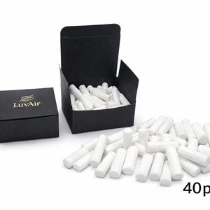 May include: A collection of white cylindrical filters, with a black box and a partially open black box filled with filters. The text "LuvAir" is on the closed box. The number "40pcs" is visible.