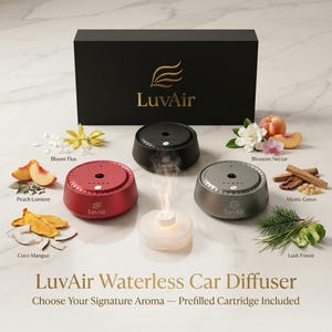 May include: A selection of LuvAir waterless car diffusers in black, red, and grey, with a black box behind them. The image showcases scent options such as Peach Lumiere, Blossom Nectar, and Lush Forest. The text reads "LuvAir Waterless Car Diffuser."