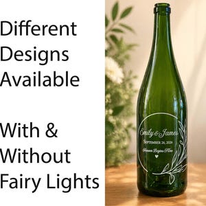 May include: A green glass bottle with a white circular label featuring the names "Emily & James", the date "September 26, 2026", and the phrase "Forever Begins Here". The bottle has a decorative floral design. Text on the left says "Different Designs Available With & Without Fairy Lights."