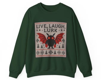 Könnte beinhalten: Dunkelgrünes Sweatshirt mit festlichem Design. Das Design zeigt eine schwarze Kreatur mit roten Flügeln und leuchtenden Augen, darüber der Text "LIVE, LAUGH, LURK". Das Design wird von einem Muster aus Schneeflocken und Bäumen umrahmt.