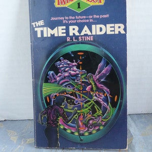 May include: A book cover for "The Time Raider" by R.L. Stine, part of the "Twistaplot" series. The cover features a colorful, psychedelic illustration of a person standing in front of a swirling, multi-colored portal.