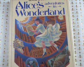 May include: A vintage hardcover book titled "Alice's Adventures in Wonderland" by Lewis Carroll, illustrated by Justin Todd. The cover features a blue-eyed girl in a blue dress, with illustrations of a fish, a bust, and a building.