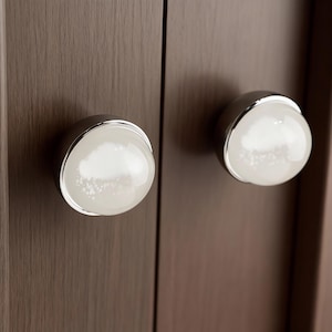 May include: A set of three ceramic mugs with a speckled, matte finish. The mugs are in shades of cream, light gray, and dark gray. Each mug has a simple, minimalist design, perfect for coffee or tea.