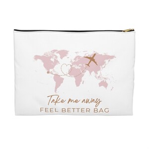 Könnte beinhalten: Weiße Reisetasche mit rosa Weltkarten-Design, goldenem Flugzeug und dem Text "Take me away". Die Tasche hat einen schwarzen Reißverschluss und die Worte "FEEL BETTER BAG" darunter.
