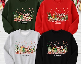 May include: Four crewneck sweatshirts in green, red, gray, and black. Each features a Christmas design with cartoon characters, snowflakes, and the word "Christmas". The names "Daniel", "Jennie", "Mommy", and "Daddy" are printed below the design.