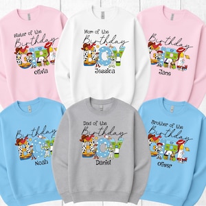Op de afbeelding: Een verzameling crewneck sweatshirts in verschillende kleuren, elk met een "Verjaardag" ontwerp en cartoonkarakters. De sweatshirts zijn gepersonaliseerd met namen als Olivia, Jessica, Jane, Noah, Daniel en Oliver.