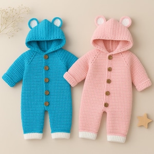 Op de afbeelding: Twee babyrompers. Eén is turquoise blauw, de andere is roze. Beide hebben een capuchon met berenoren, houten knopen en witte manchetten. De gebreide outfits zijn ontworpen voor baby's.