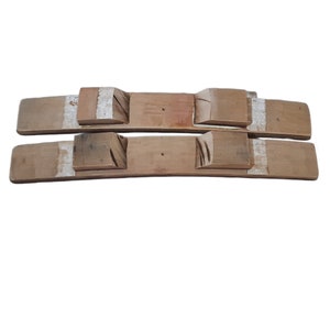 May include: Two wooden barrel staves with white painted stripes. The staves are curved and have a natural wood finish.