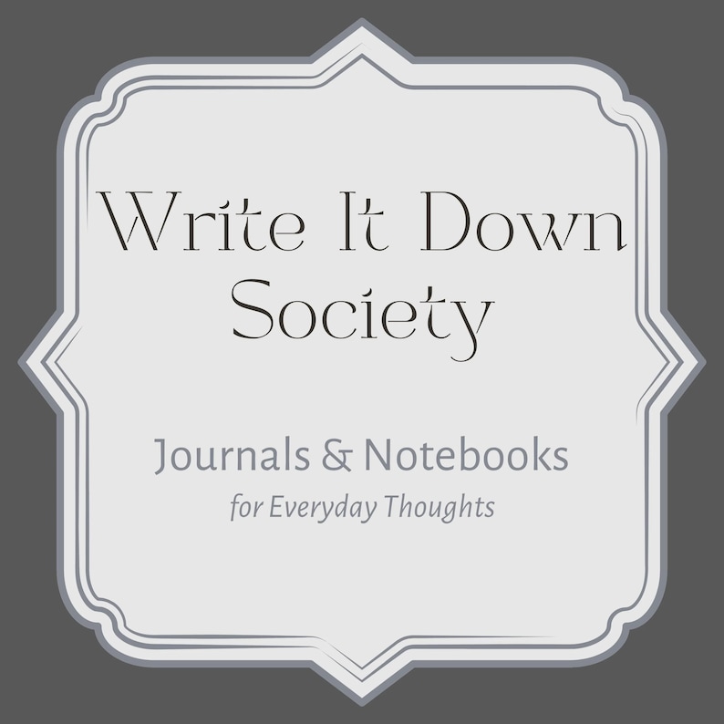 May include: A light gray framed graphic with the text "Write It Down Society" in a serif font. Below the title are the words "Journals & Notebooks" and "for Everyday Thoughts" in a sans-serif font. The background is a dark gray.