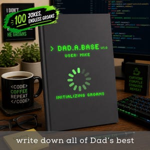May include: A black notebook with the text "DAD.A.BASE" and "INITIALIZING GROANS" in green. A coffee mug with "<CODE> COFFEE REPEAT </CODE>" is next to the notebook. A sign says "100 JOKES, ENDLESS GROANS".