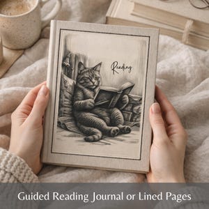May include: A journal with a cat illustration reading a book. The cover has the word "Reading" in script. The journal is held by a person. The bottom of the image has the text "Guided Reading Journal or Lined Pages".