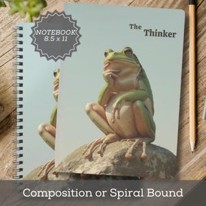 May include: Spiral-bound notebook featuring a green frog in a thinking pose, with the text "The Thinker" and "NOTEBOOK 8.5 x 11". The notebook has a light blue background and a pencil is visible on the right.