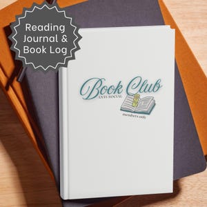 May include: A white reading journal and book log with a graphic on the cover featuring an open book, a yellow bookmark, and the text Book Club Anti-Social members only. The journal is placed on top of a dark gray notebook and an orange notebook.