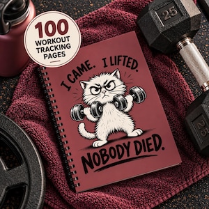 Könnte beinhalten: Ein spiralgebundenes Notizbuch mit dunkelrotem Einband, das eine weiße Cartoon-Katze beim Heben von Hanteln zeigt. Der Text lautet I CAME. I LIFTED. NOBODY DIED. Ein kreisförmiges Abzeichen auf dem Einband gibt 100 WORKOUT TRACKING PAGES an. Das Notizbuch ist von Sportgeräten umgeben.