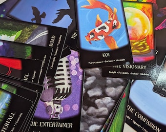 May include: A collection of rectangular oracle cards featuring diverse illustrations including a koi fish, a crystal ball, a microphone, and silhouettes. Each card displays a title and descriptive keywords such as Koi, The Visionary, and The Entertainer.