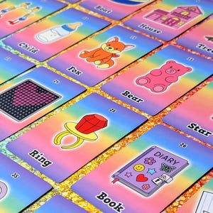 May include: A collection of colorful flashcards with various illustrations and words. The cards feature images of a fox, bear, ring, and diary, among others. The background has a rainbow gradient.