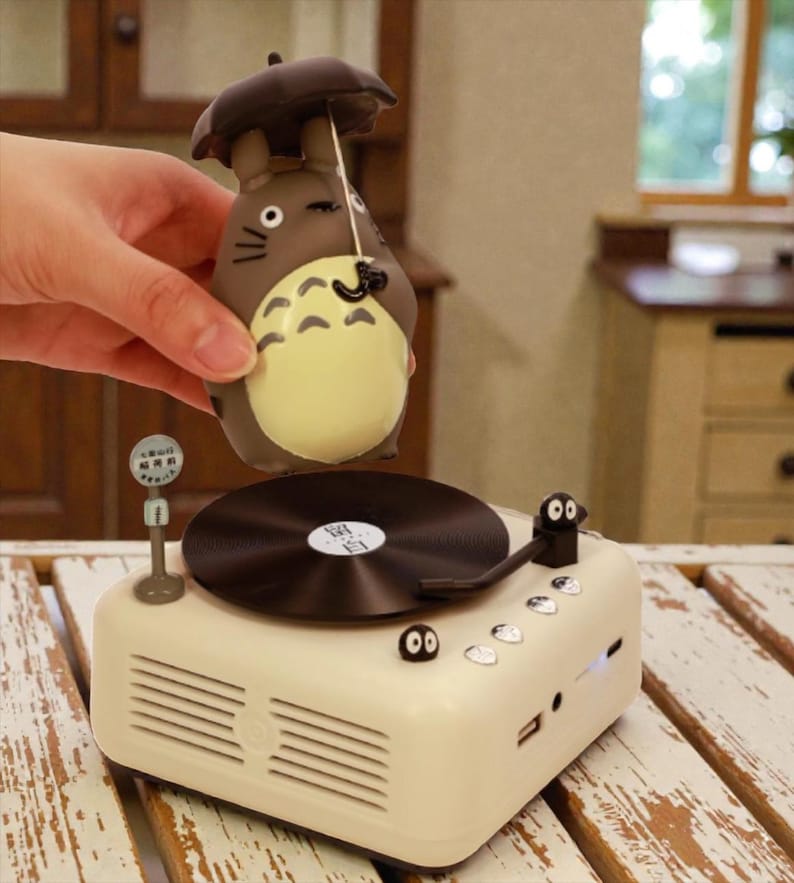Pu&ograve; includere: Un giradischi in stile retr&ograve; color crema con un disco in vinile nero e una statuetta di un personaggio dei cartoni animati. La statuetta &egrave; marrone con la pancia gialla e tiene un piccolo ombrello. Il giradischi ha una piccola antenna e una porta USB.