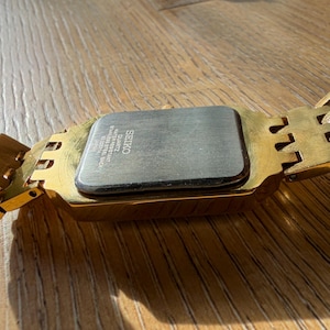 Pu&ograve; includere: Un orologio da polso color oro con cassa rettangolare e bracciale a maglie abbinato. Il retro della cassa &egrave; in acciaio inossidabile color argento e riporta la scritta SEIKO, QUARTZ, WATER RESISTANT, STAINLESS STEEL BACK e JAPAN.
