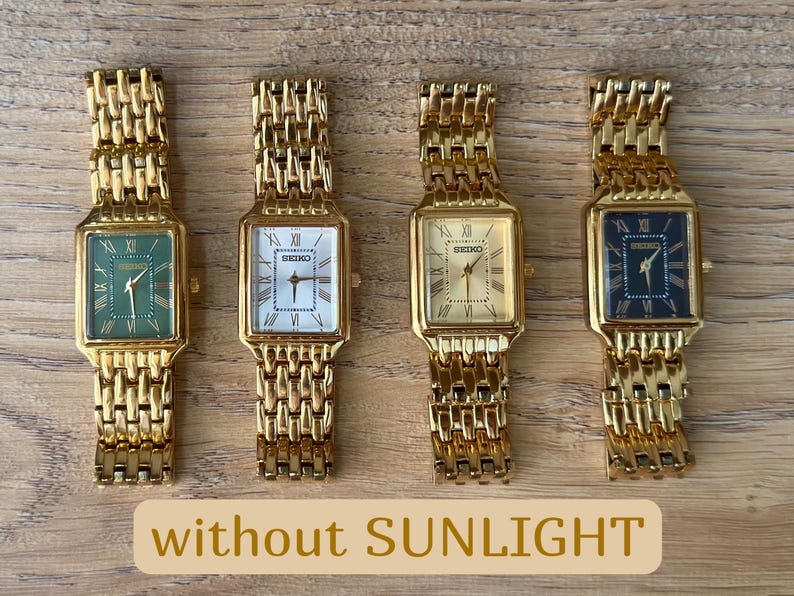 Pu&ograve; includere: Quattro orologi da polso rettangolari Seiko con cinturini a maglie color oro. Gli orologi presentano quadranti verde, bianco, oro e nero, ciascuno con numeri romani e lancette dorate. Il testo without SUNLIGHT &egrave; visibile.