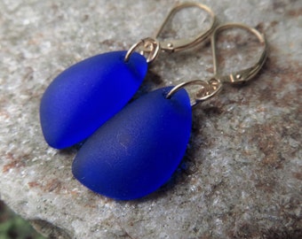 May include: A pair of earrings with gold hooks and blue glass teardrop-shaped pendants.