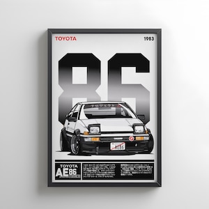 May include: Framed poster with a white Toyota AE86 Trueno car illustration. The poster includes the text "TOYOTA" and "1983" at the top, with a large "86" graphic behind the car. The car's license plate reads "AE86".