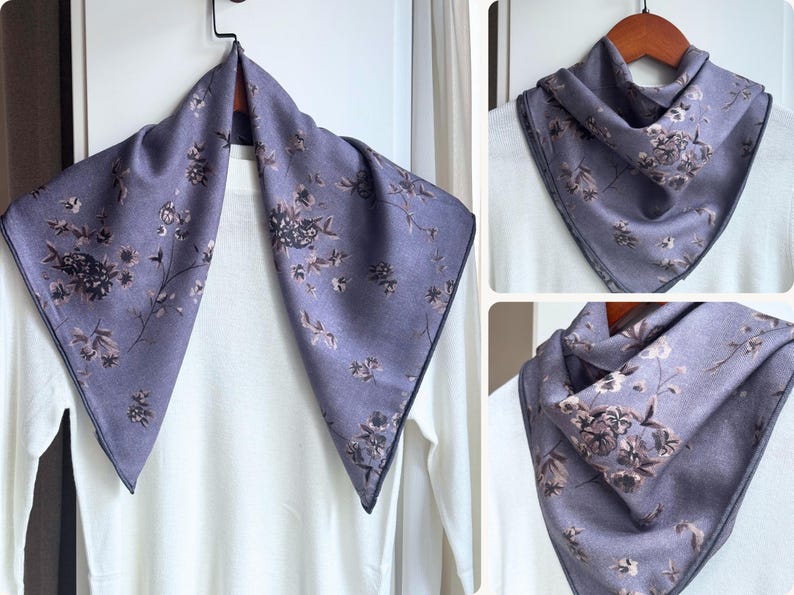 May include: A lavender scarf with a floral pattern. The scarf is displayed on a hanger, showcasing its square shape and dark trim. The floral design features various flower and leaf shapes.