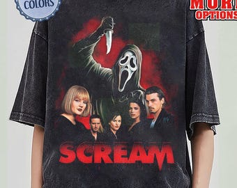 Peut inclure: T-shirt gris foncé avec un graphisme du film "Scream". Le motif comprend le tueur Ghostface tenant un couteau, le titre du film en rouge et des images des acteurs. Le t-shirt porte également les mentions "Comfort Colors" et "Best Offer More Options."