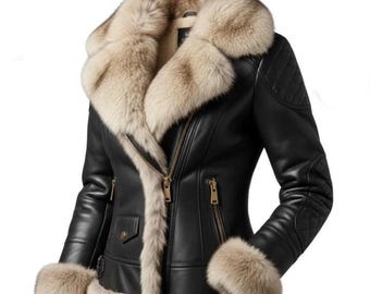 Könnte beinhalten: Schwarze Lederjacke mit beigem Pelzkragen, Manschetten und Besatz. Die Jacke hat einen diagonalen Reißverschluss, eine kleine Tasche und eine Steppung an den Schultern. Das Fell ist hellbraun.