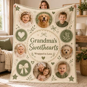 Puede incluir: Una manta de forro polar color crema con el texto "Grandma's Sweethearts" y "Wrapped in Love" en letra verde oscuro. El diseño incluye marcos de fotos circulares de niños y perros, intercalados con ilustraciones verdes de corazones, estrellas y lazos.