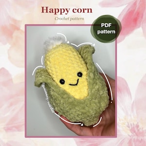 May include: A crocheted corn plushie with a smiling face, featuring a yellow corn kernel and green husk. The text "Happy corn" and "Crochet pattern" are displayed above the plushie. A green circle with "PDF pattern" is in the top right corner.
