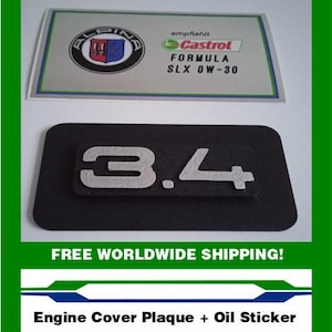 May include: A black engine cover plaque with the number "3.4" in silver. Above it is a sticker with the Alpina logo and Castrol Formula SLX 0W-30 text. The image also includes the text "Engine Cover Plaque + Oil Sticker".