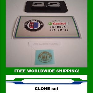 May include: A set of automotive decals and emblems, including a black "3.3" emblem, a Castrol Formula SLX 0W-30 sticker, and an Alpina logo sticker. The set is presented on a white background.