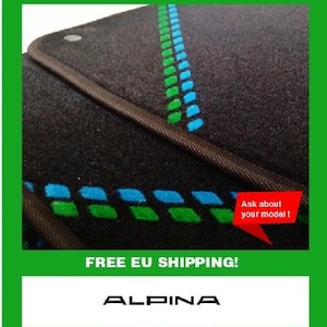Könnte beinhalten: Schwarze Auto-Fußmatte mit grünem und blauem Design. Die Matte hat einen braunen Rand und das Wort "ALPINA" ist unten sichtbar. Eine rote Sprechblase sagt "Ask about your model!"
