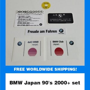 Może przedstawiać: Zestaw naklejek i etykiet BMW Japan z lat 90. i 2000. Zestaw zawiera różne prostokątne i okrągłe naklejki z logo BMW, japońskim tekstem i frazą "Freude am Fahren."