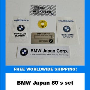 Puede incluir: Un conjunto de pegatinas y distintivos BMW Japan de los años 80. Incluye una pegatina del BMW Club of Japan, una pegatina de BMW Japan Corp. y una pegatina de servicio 24 horas. El conjunto presenta el logotipo de BMW.